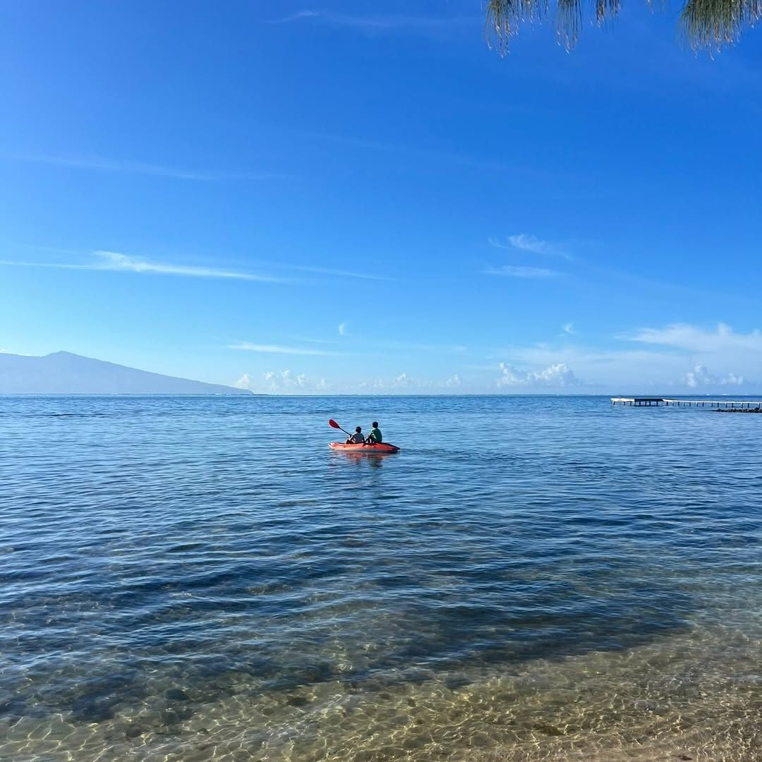 Deux personnes en kayak sur le lagon bleu, Tahiti au loin